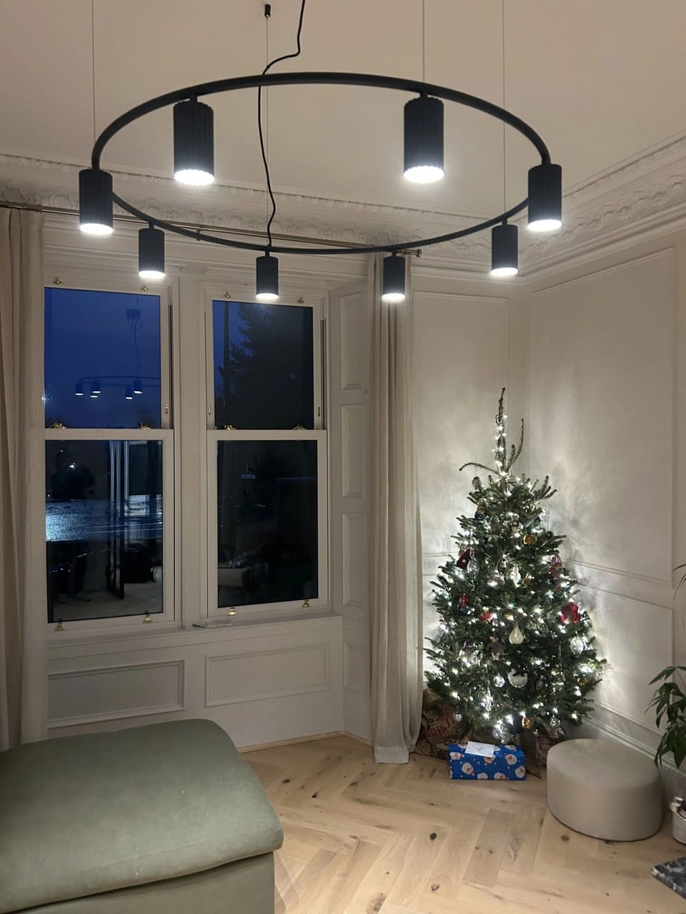 A circular pendant light with spotlights in a living room